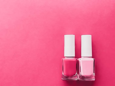 Gül arka planında pembe oje şişeleri, manikür ve güzellik kozmetik konsepti