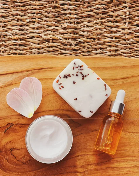 Tahta arka planda cilt bakımı, kaplıca ve vücut bakımı kozmetik ürünleri, düz dizayn, organik güzellik rutini ve doğal kozmetik konsepti