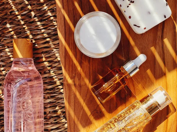 Tahta arka planda cilt bakımı, kaplıca ve vücut bakımı kozmetik ürünleri, düz dizayn, organik güzellik rutini ve doğal kozmetik konsepti