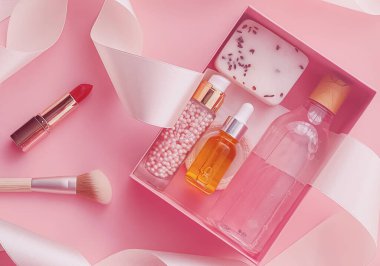 Pembe arka planda güzellik kutusu aboneliği, spa ve makyaj ürünleri, düz dizayn, doğal kozmetik hediye teslim konsepti