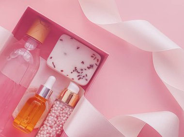 Pembe arka planda güzellik kutusu aboneliği, spa ve makyaj ürünleri, düz dizayn, doğal kozmetik hediye teslim konsepti