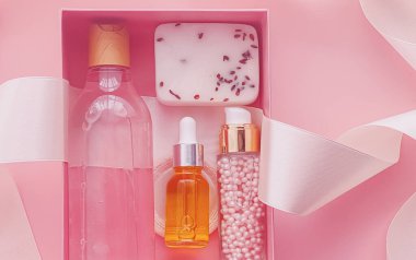 Pembe arka planda güzellik kutusu aboneliği, spa ve makyaj ürünleri, düz dizayn, doğal kozmetik hediye teslim konsepti