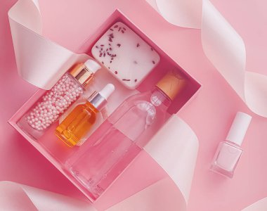 Pembe arka planda güzellik kutusu aboneliği, spa ve makyaj ürünleri, düz dizayn, doğal kozmetik hediye teslim konsepti