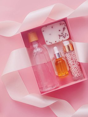 Pembe arka planda güzellik kutusu aboneliği, spa ve makyaj ürünleri, düz dizayn, doğal kozmetik hediye teslim konsepti