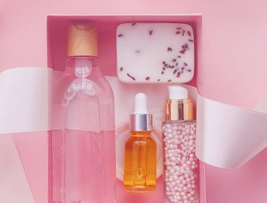 Pembe arka planda güzellik kutusu aboneliği, spa ve makyaj ürünleri, düz dizayn, doğal kozmetik hediye teslim konsepti