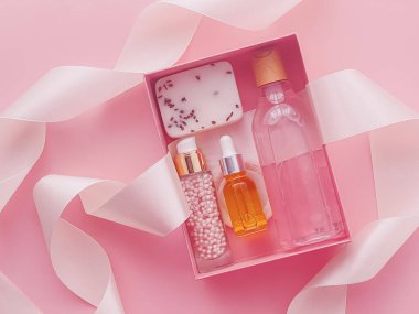 Pembe arka planda güzellik kutusu aboneliği, spa ve makyaj ürünleri, düz dizayn, doğal kozmetik hediye teslim konsepti