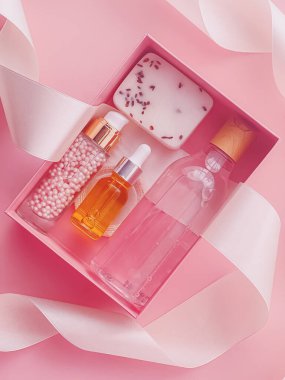 Pembe arka planda güzellik kutusu aboneliği, spa ve makyaj ürünleri, düz dizayn, doğal kozmetik hediye teslim konsepti