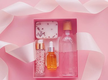 Pembe arka planda güzellik kutusu aboneliği, spa ve makyaj ürünleri, düz dizayn, doğal kozmetik hediye teslim konsepti