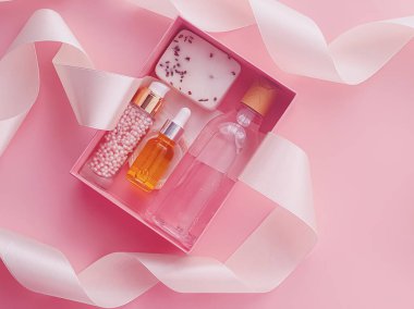 Pembe arka planda güzellik kutusu aboneliği, spa ve makyaj ürünleri, düz dizayn, doğal kozmetik hediye teslim konsepti