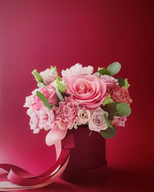 Kırmızı arka planda güzel bir çiçek kutusu, çiçek buketi bayram hediyesi olarak, lüks çiçek tasarımı konsepti