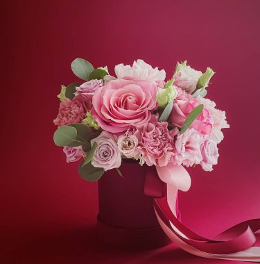 Kırmızı arka planda güzel bir çiçek kutusu, çiçek buketi bayram hediyesi olarak, lüks çiçek tasarımı konsepti