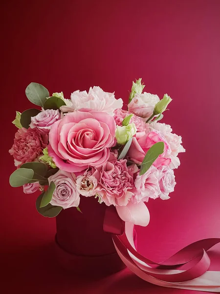 Kırmızı arka planda güzel bir çiçek kutusu, çiçek buketi bayram hediyesi olarak, lüks çiçek tasarımı konsepti