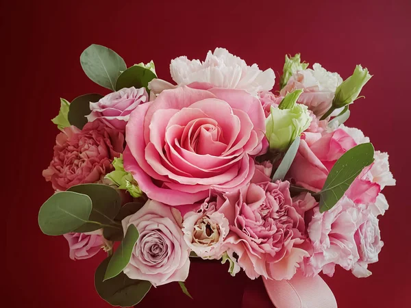 Kırmızı arka planda güzel bir çiçek kutusu, çiçek buketi bayram hediyesi olarak, lüks çiçek tasarımı konsepti