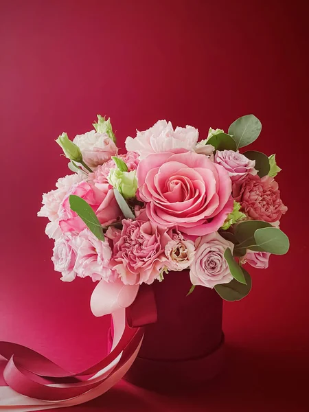 Kırmızı arka planda güzel bir çiçek kutusu, çiçek buketi bayram hediyesi olarak, lüks çiçek tasarımı konsepti