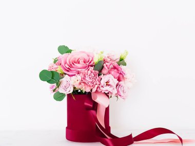 Beyaz arka planda kırmızı çiçek kutusundaki güzel çiçek buketi, bayram hediyesi, lüks çiçek tasarımı konsepti
