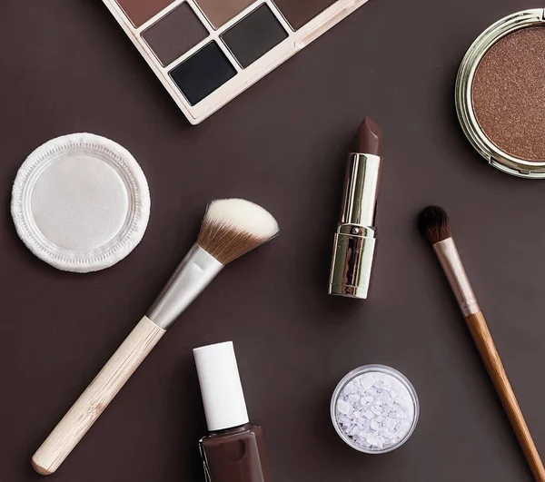 Beauty, make-up and cosmetics flatlay design with copyspace, cosmetic products and makeup tools on brown background, girly and feminine style concept