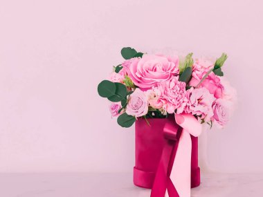 Pembe arka planda çiçek kutusundaki güzel çiçek buketi, bayram hediyesi, lüks çiçek tasarımı konsepti