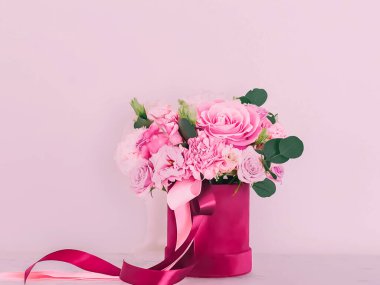 Pembe arka planda çiçek kutusundaki güzel çiçek buketi, bayram hediyesi, lüks çiçek tasarımı konsepti