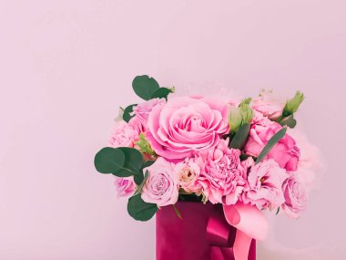 Pembe arka planda çiçek kutusundaki güzel çiçek buketi, bayram hediyesi, lüks çiçek tasarımı konsepti