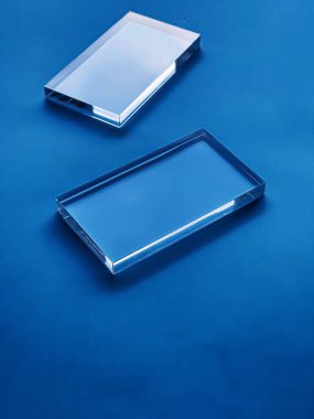 Transparent glass device on blue background, future technology and abstract screen mockup design concept