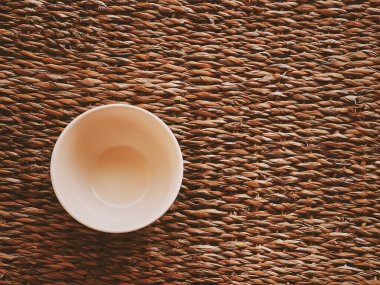 Kırsal hasır arka planda küçük boş seramik ölçü kaseleri, gıda hazırlama düzlüğü ve pişirme tasarımı konsepti