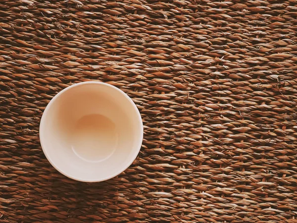 Kırsal hasır arka planda küçük boş seramik ölçü kaseleri, gıda hazırlama düzlüğü ve pişirme tasarımı konsepti