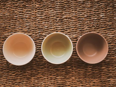 Kırsal hasır arka planda küçük boş seramik ölçü kaseleri, gıda hazırlama düzlüğü ve pişirme tasarımı konsepti