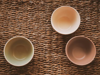 Kırsal hasır arka planda küçük boş seramik ölçü kaseleri, gıda hazırlama düzlüğü ve pişirme tasarımı konsepti