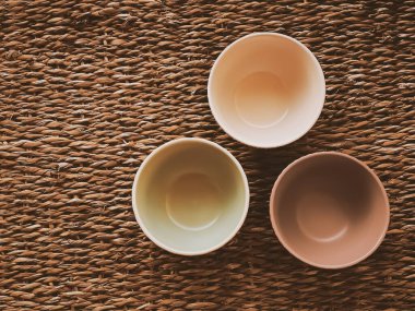 Kırsal hasır arka planda küçük boş seramik ölçü kaseleri, gıda hazırlama düzlüğü ve pişirme tasarımı konsepti