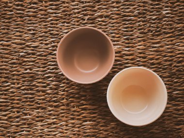 Kırsal hasır arka planda küçük boş seramik ölçü kaseleri, gıda hazırlama düzlüğü ve pişirme tasarımı konsepti