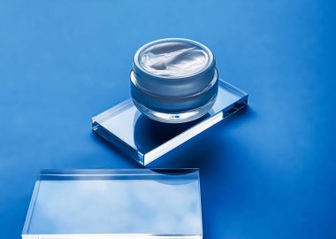 Cam ve mavi arka planda yüz kremi kavanozu, güzellik ürünü ve cilt bakımı, kozmetik bilimi konsepti