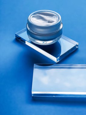 Cam ve mavi arka planda yüz kremi kavanozu, güzellik ürünü ve cilt bakımı, kozmetik bilimi konsepti