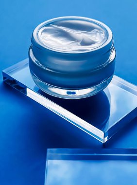 Cam ve mavi arka planda yüz kremi kavanozu, güzellik ürünü ve cilt bakımı, kozmetik bilimi konsepti