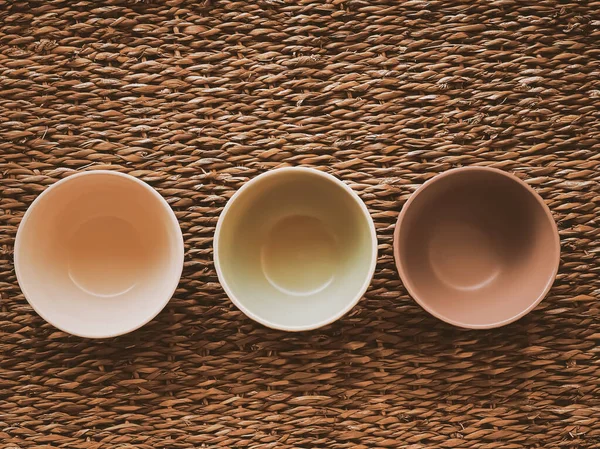 Kırsal hasır arka planda küçük boş seramik ölçü kaseleri, gıda hazırlama düzlüğü ve pişirme tasarımı konsepti