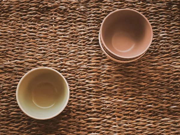 Kırsal hasır arka planda küçük boş seramik ölçü kaseleri, gıda hazırlama düzlüğü ve pişirme tasarımı konsepti