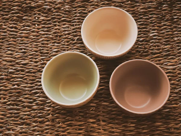 Kırsal hasır arka planda küçük boş seramik ölçü kaseleri, gıda hazırlama düzlüğü ve pişirme tasarımı konsepti