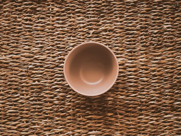 Kırsal hasır arka planda küçük boş seramik ölçü kasesi, yemek hazırlama düzlüğü ve pişirme tasarımı konsepti