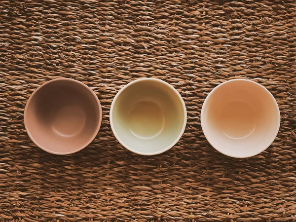 Kırsal hasır arka planda küçük boş seramik ölçü kaseleri, gıda hazırlama düzlüğü ve pişirme tasarımı konsepti