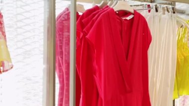 Butikte lüks kadın moda koleksiyonu, giyim mağazası perakendecisi ve alışveriş konseptinde askılarda çeşitli şık kıyafetler.