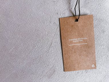 Geri dönüşümlü polyester moda etiketi, lüks kumaş arka planında indirim kartı, alışveriş ve perakende konsepti içeriyor