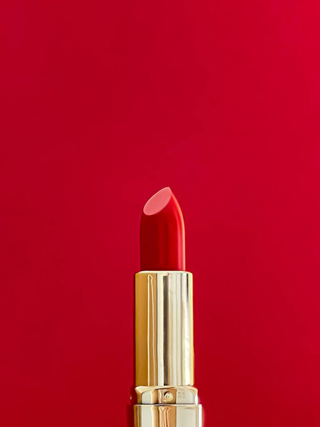 Красная помада в золотой трубке на цветном фоне, роскошный макияж и косметика для дизайна бренда красоты