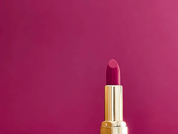 Purple lipstick in golden tube on colour background, luxury make-up and cosmetics for beauty brand product design concept