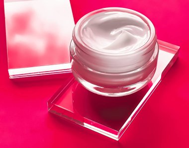 Cam ve pembe arka planda yüz kremi kavanozu, güzellik ürünü ve cilt bakımı, kozmetik bilimi konsepti