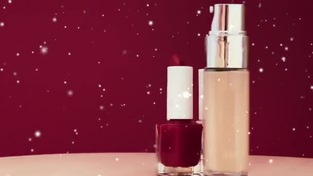クリスマス 化粧品 美容ブランドのコンセプトのための豪華な化粧品や雪の効果として赤い口紅 液体の基盤とネイルポリッシュボトル — ストック動画