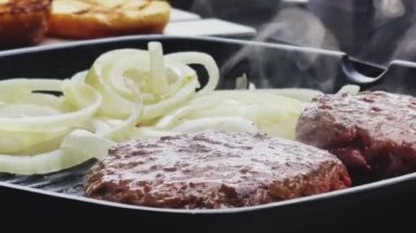 Bahçe konseptinde ızgara et, kızartma tavasında kırmızı et, dökme demir ızgara tavada kıymalı burger pişirmek.