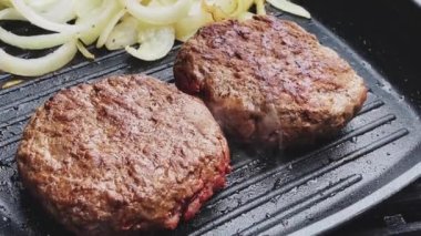 Bahçe konseptinde ızgara et, kızartma tavasında kırmızı et, dökme demir ızgara tavada kıymalı burger pişirmek.