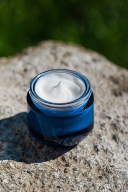 Güzellik kremi, cilt kremi ve kozmetik ürünleri yazın gün batımında taştan arka plan, kozmetik ürünler ve cilt bakımı konsepti.