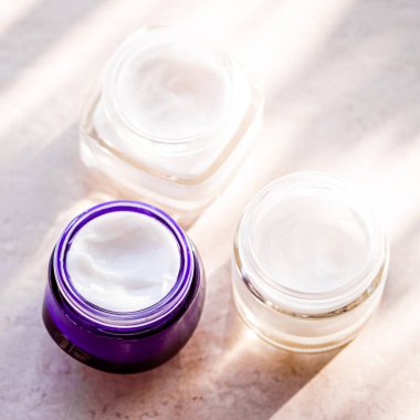 Güzellik kremi kavanozları, cilt bakımı ve kozmetik ürünleri yazın gün batımında taştan arka planda, kozmetik ürünleri ve cilt bakımı konsepti.