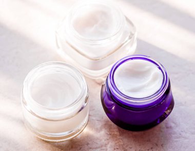 Güzellik kremi kavanozları, cilt bakımı ve kozmetik ürünleri yazın gün batımında taştan arka planda, kozmetik ürünleri ve cilt bakımı konsepti.