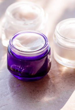 Güzellik kremi kavanozları, cilt bakımı ve kozmetik ürünleri yazın gün batımında taştan arka planda, kozmetik ürünleri ve cilt bakımı konsepti.